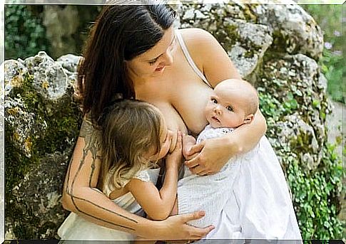 Mother breastfeeding two children