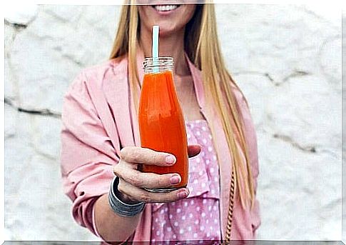 Girl holding a bottle of carrot juice